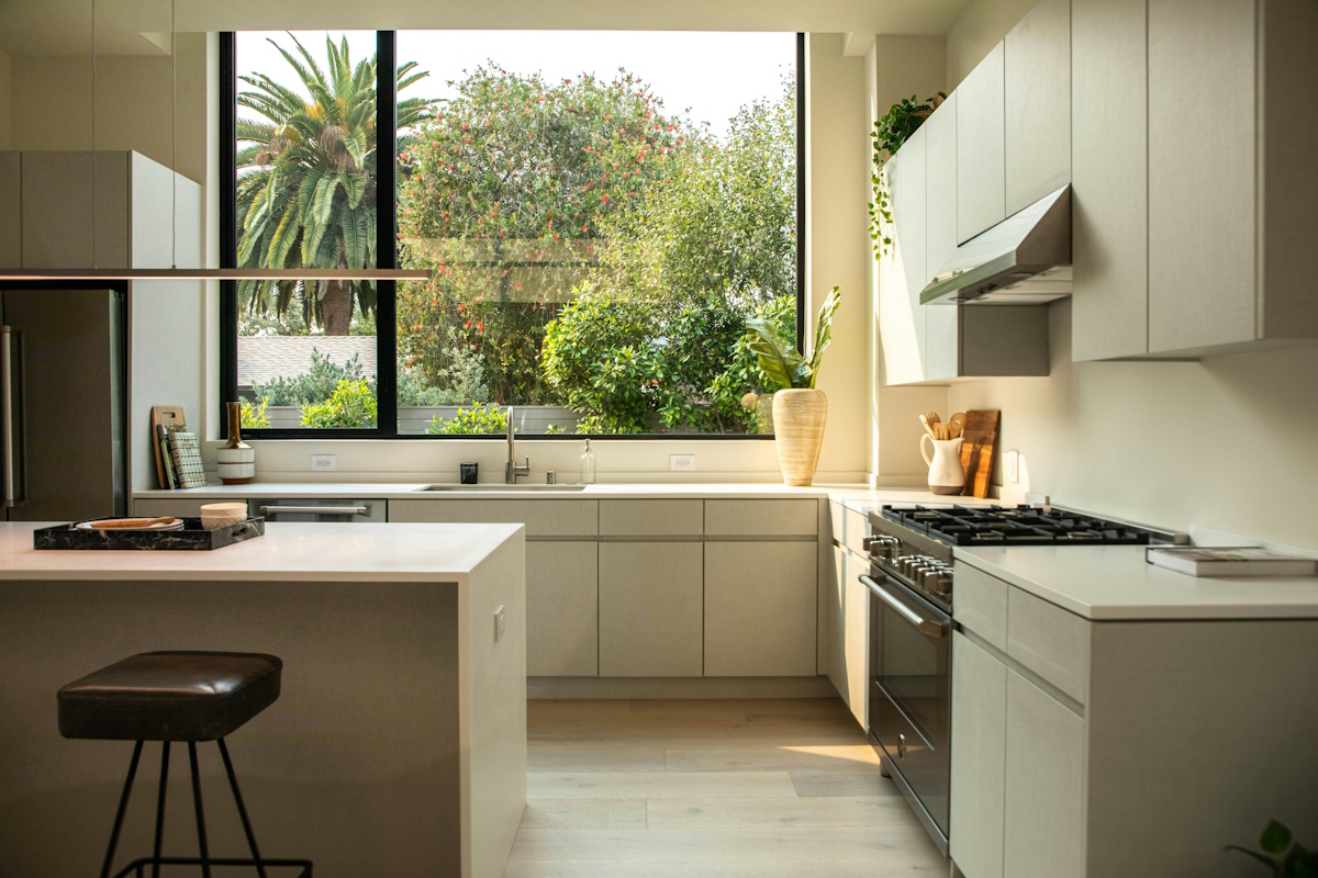 Photo of a cream kitchen and a large window showing the garden beyond